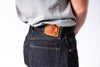 Person wearing Levi's jeans with the brand logo on the pocket against a white background