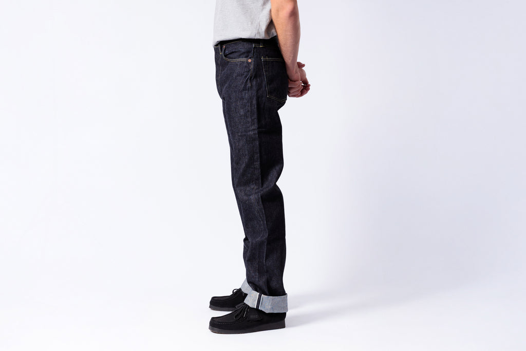 Person wearing dark jeans on a white background