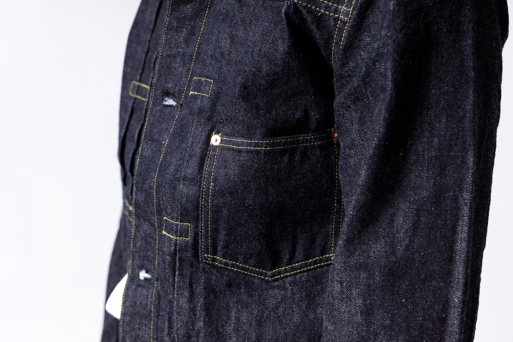 Dark denim jacket with visible stitching details on a white background
