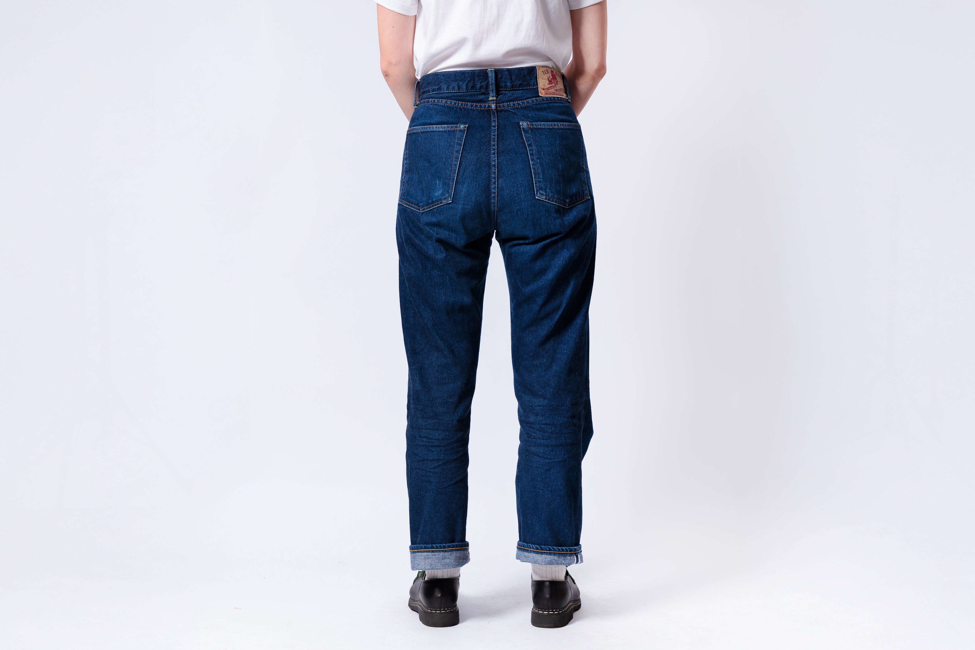 Person wearing blue jeans on a white background