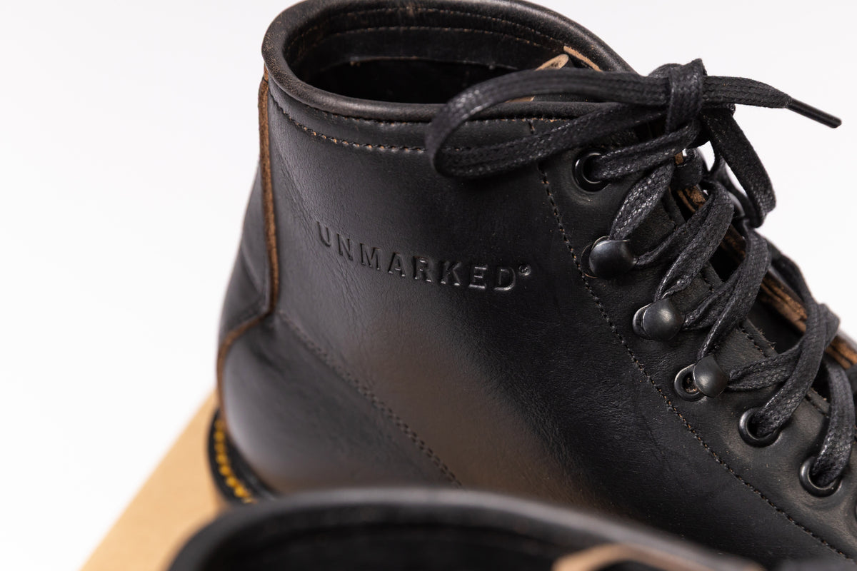 Black leather boot with 'UNMARKED' branding on a white background