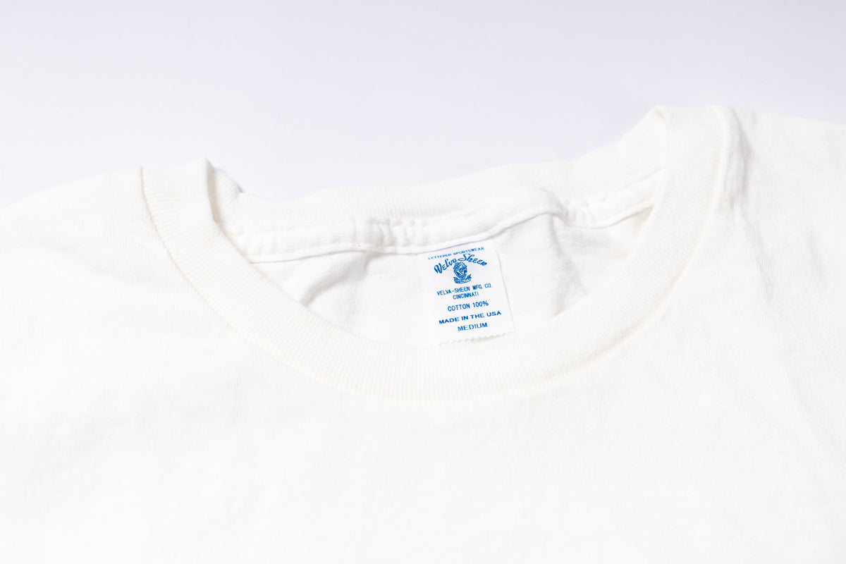White shirt with a brand label on a light gray background