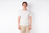 Man wearing a white t-shirt and beige pants against a white background