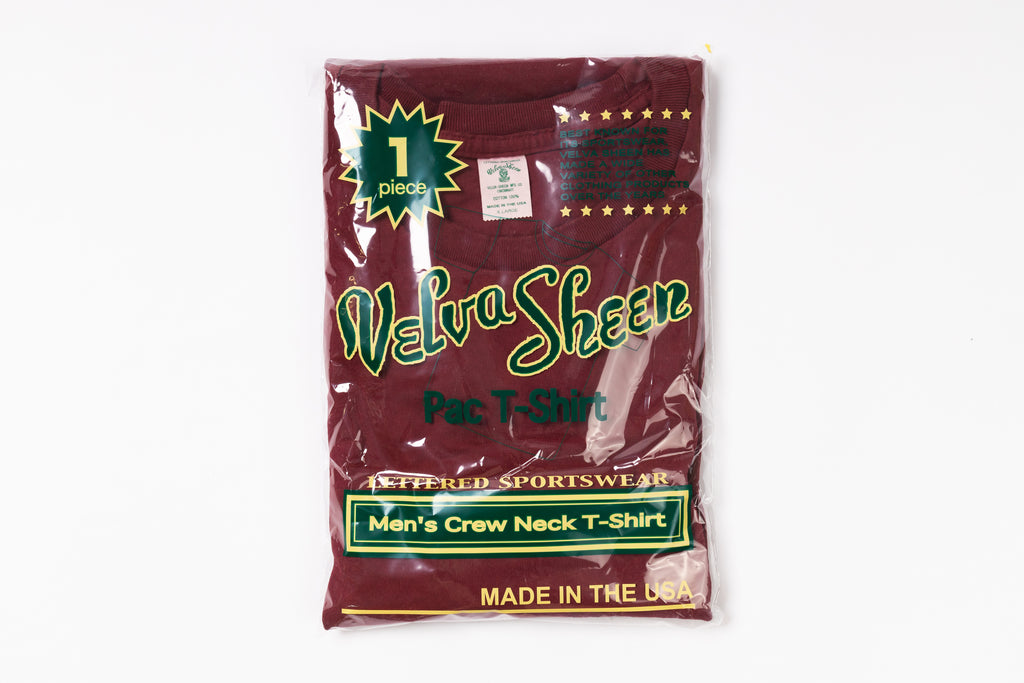 Packaged maroon t-shirt with branding on a white background