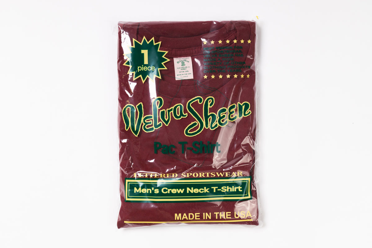 Packaged maroon t-shirt with branding on a white background