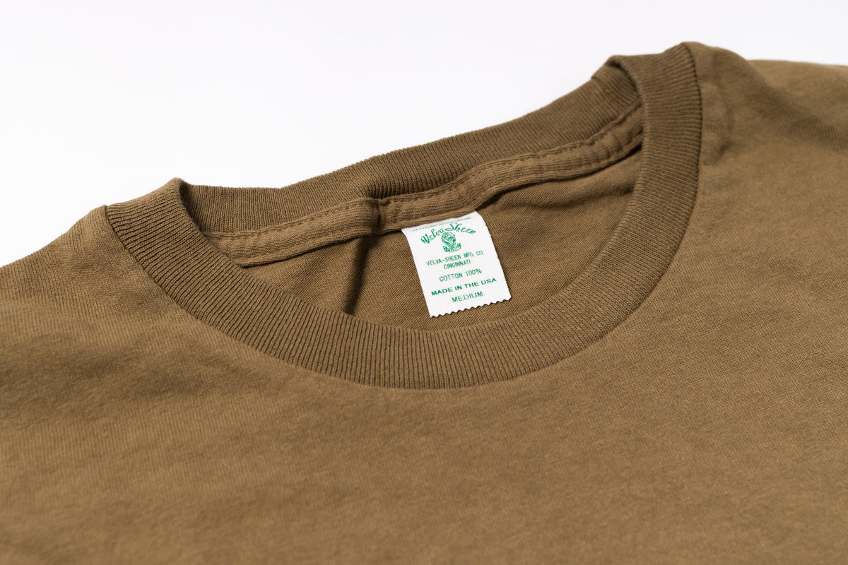 Close-up of a brown shirt with a tag on a white background