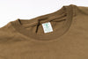 Close-up of a brown shirt with a tag on a white background
