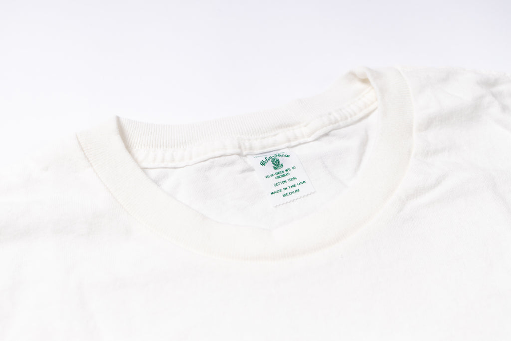 Close-up of a white shirt with a brand label on a white background