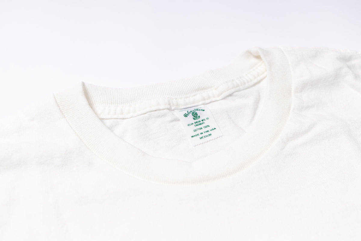 Close-up of a white shirt with a brand label on a white background