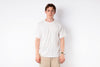 Person wearing a plain white t-shirt and beige pants against a white background