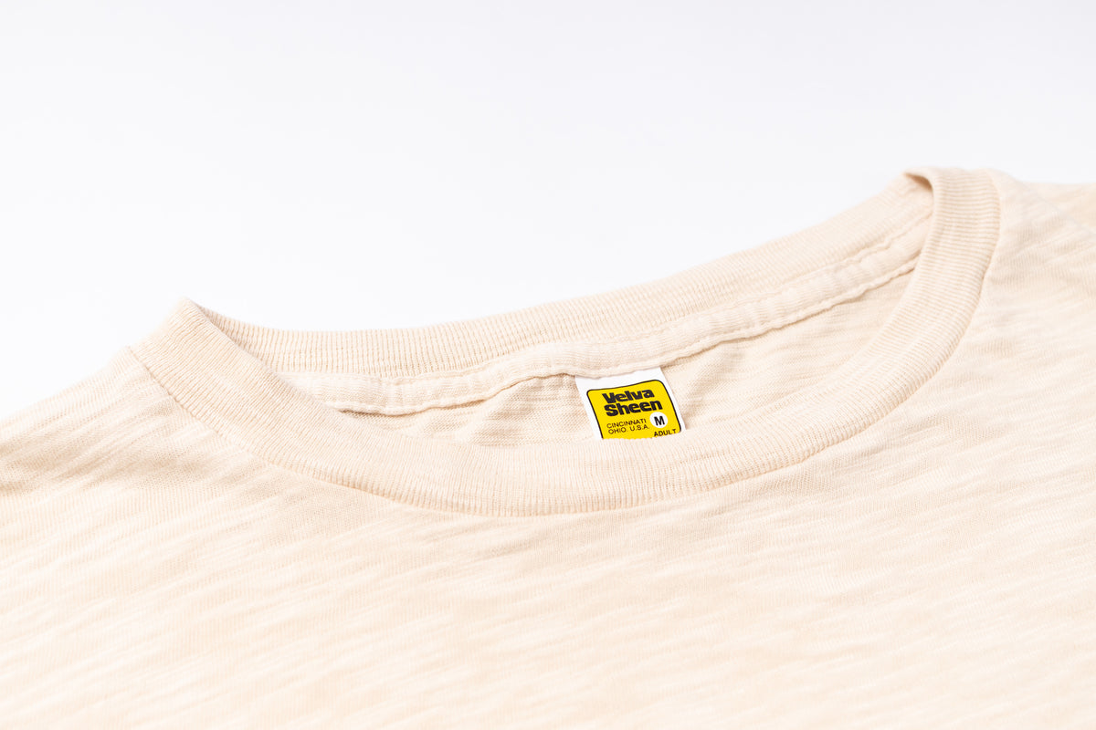 Beige t-shirt with a label on a white background