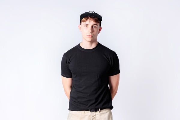 Person wearing a black t-shirt and cap on a white background